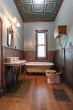 Bathroom with coffered ceiling, toilet, a bath, and hardwood / wood-style flooring