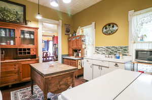 Kitchen with a kitchen island, hanging light fixtures, plenty of natural light, and dark hardwood / wood-style flooring