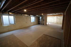 Unfinished basement area with large windows and natural light