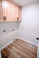 Laundry area featuring washer hookup, electric dryer hookup, cabinets, and light wood-type flooring