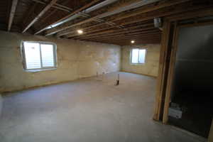 Unfinished basement area with large windows and natural light