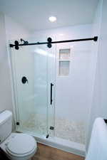 Primary bathroom with custom shower with subway tile, stone, and frameless shower door