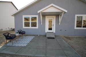 Entrance to property with central AC and a patio area