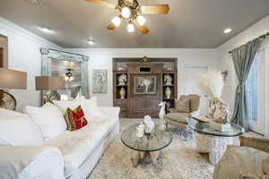 Living area featuring crown molding and ceiling fan