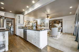 Kitchen featuring crown molding, a sink, a peninsula, stainless steel appliances, and white cabinetry