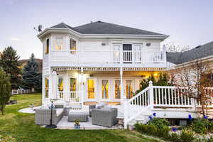 Rear view of house with an outdoor hangout area, a yard, roof with shingles, and a balcony