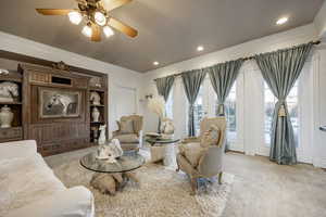 Living area featuring ornamental molding, light carpet, recessed lighting, and ceiling fan