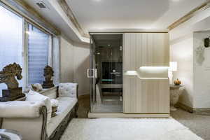 Sitting room with baseboards, a textured wall, carpet, and visible vents