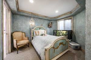 Carpeted bedroom featuring crown molding, recessed lighting, and a notable chandelier