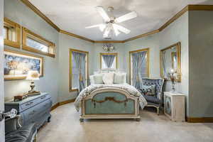 Bedroom featuring baseboards, a ceiling fan, crown molding, and light carpet