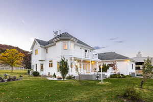 Back of property with an outdoor living space, fence, a balcony, a yard, and a patio