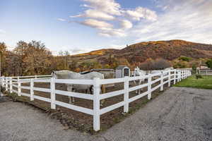View of yard featuring a fenced front yard, a mountain view, and a rural view