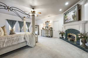 Carpeted bedroom with crown molding, recessed lighting, ceiling fan, and a high end fireplace
