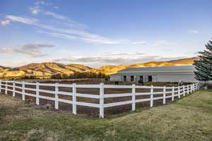 View of yard with fence, an outbuilding, and a mountain view