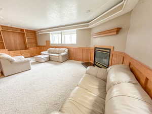 Living room featuring wood walls, carpet floors, and a textured ceiling