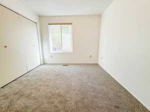 Unfurnished bedroom featuring carpet flooring and a closet