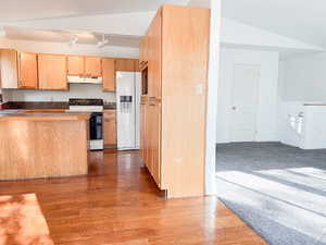 Kitchen with lofted ceiling, sink, light hardwood / wood-style flooring, light brown cabinetry, and white appliances