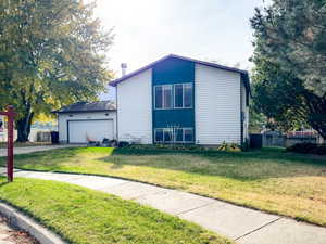 View of side of home with a lawn and a garage