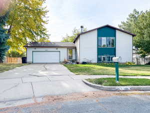 View of front of property with a front lawn and a garage