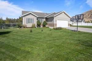 View of front facade featuring a garage and a front lawn