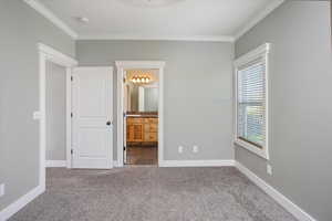 Primary bedroom. Features carpet floors, ornamental molding and ensuite bath.