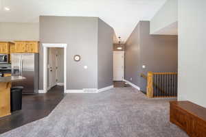 View of front door, kitchen, laundry room, stairs, and living room.