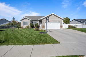 Ranch-style house featuring a front yard and a garage