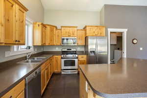 Kitchen with oven, stove, washer, sink, and refrigerator/freezer. Appliances with stainless steel finishes.