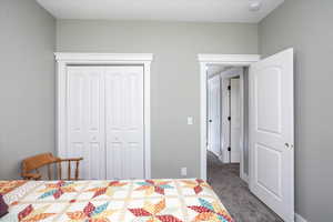 Bedroom 3 featuring dark colored carpet and a closet