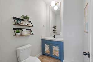 Bathroom with hardwood / wood-style floors, vanity, and toilet