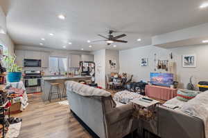 ADU: Living room with ceiling fan, plenty of natural light, a textured ceiling, and light hardwood / wood-style flooring