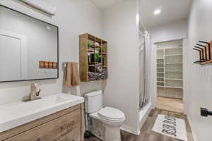 Bathroom featuring hardwood / wood-style floors, vanity, toilet, and a shower with shower curtain