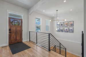 Entrance foyer featuring a notable chandelier and light wood-type flooring