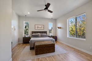 Bedroom featuring light hardwood / wood-style flooring, multiple windows, and ceiling fan