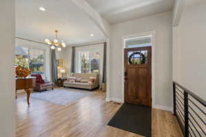 Foyer entrance with light wood-type flooring, plenty of natural light, and a chandelier