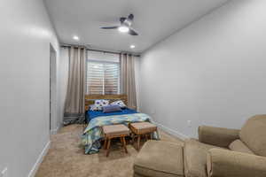 Carpeted bedroom featuring ceiling fan