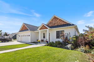 View of front of property with a front yard and a garage