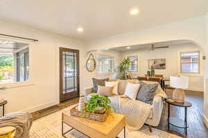 Main level living room and dining area, featuring ceiling fan, hardwood flooring, and plenty of natural light