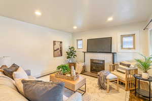 Main level living room featuring hardwood flooring, a fireplace, and a wealth of natural light