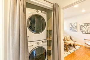 Main level laundry room with a stacked washer and dryer and bamboo hardwood floors