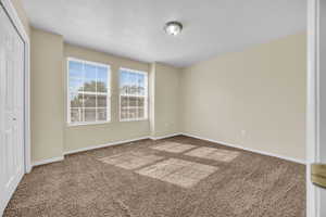 Unfurnished bedroom with a closet, carpet flooring, and a textured ceiling