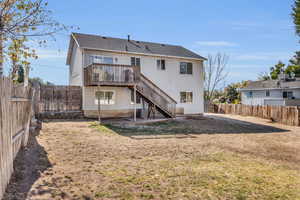 Rear view of property with cooling unit, a wooden deck, and a lawn