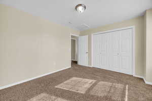 Unfurnished bedroom featuring a closet and carpet