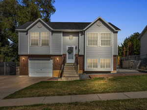 Split foyer home with a front yard and a garage