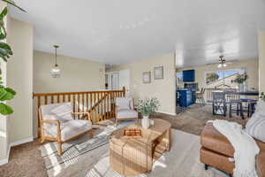 Carpeted living room featuring ceiling fan and a textured ceiling