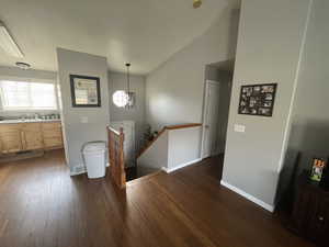 Foyer entrance with sink, dark hardwood / wood-style floors, and vaulted ceiling