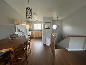 Dining room featuring dark wood-type flooring, sink, and a chandelier