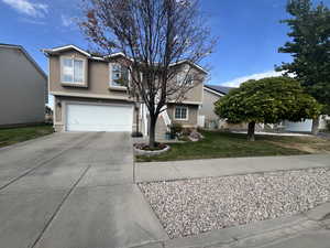 View of front of house with a front yard and a garage