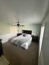 Carpeted bedroom featuring ceiling fan, a closet, and a textured ceiling