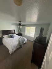 Bedroom featuring ceiling fan, carpet, and a textured ceiling